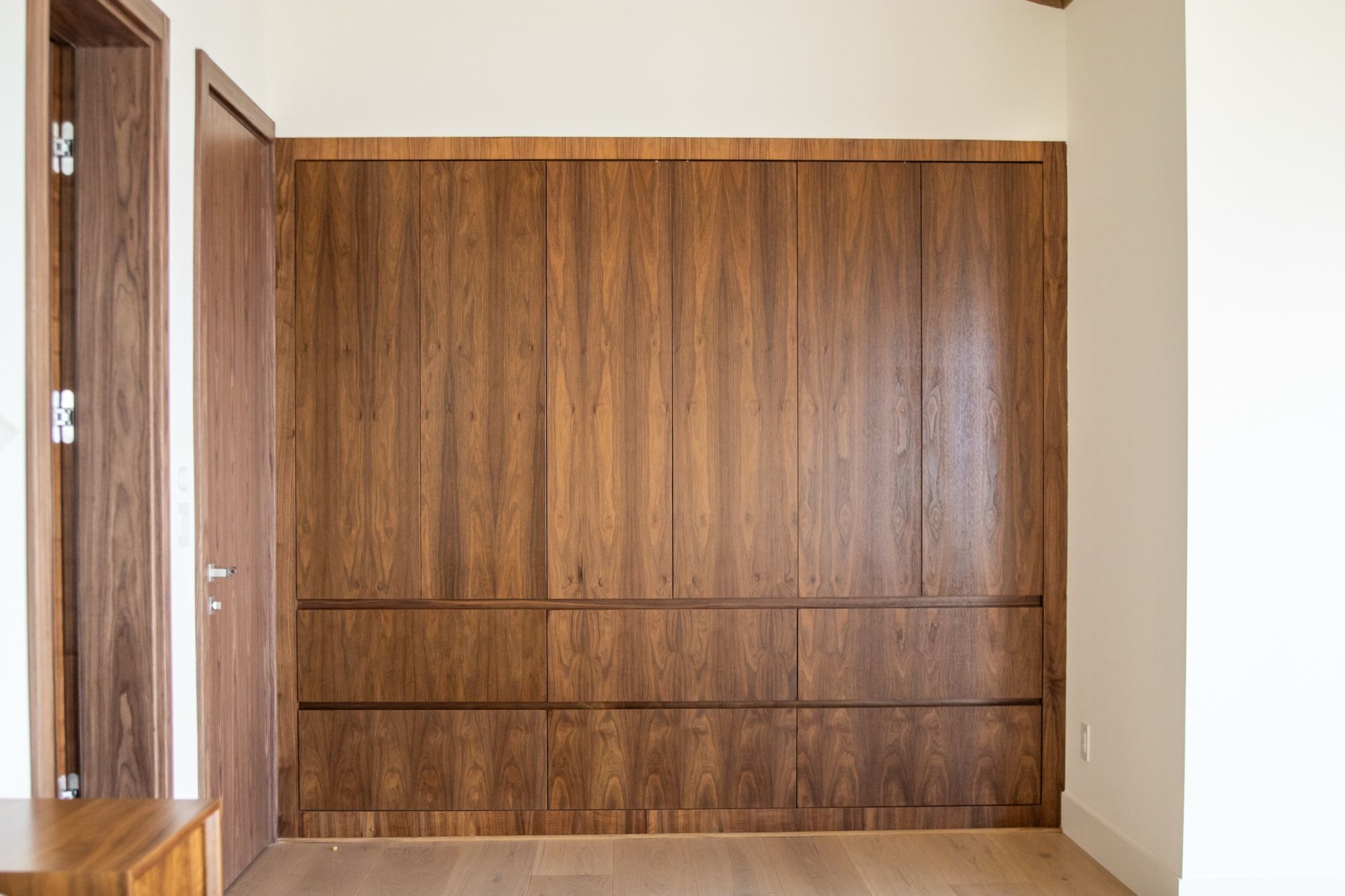 Book-matched walnut panel wall with hidden storage