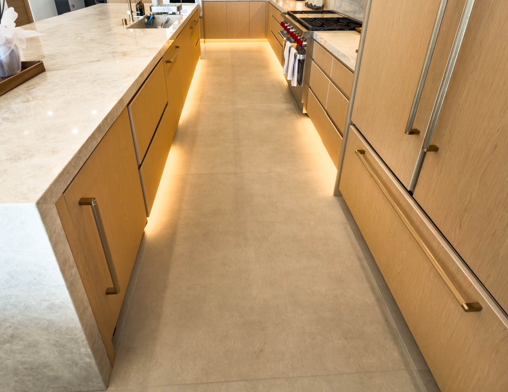 White oak galley with integrated pulls and glowing under-cabinet lighting